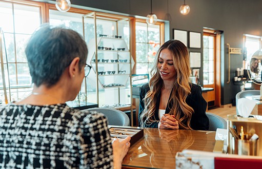 two women, discussing eyeglasses and sharing insights